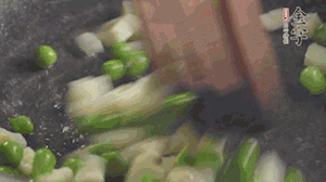 鍋中油7成熱時，入青豆、筍丁翻炒，然后加糯米飯加鹽均勻翻炒。