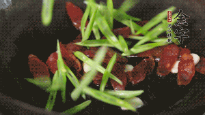 先后下香腸片、四季豆絲均勻翻炒，加適量清水燜煮一下。