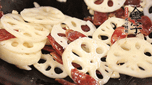 依次下香腸片、藕片翻炒均勻，加適量清水燜熟。