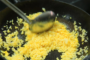 大火加熱炒鍋，再入油，燒到四至五成熱時(shí)倒入雞蛋液，在未凝結(jié)之前，加米飯煸炒，不停翻炒并用鍋鏟將成塊的米飯碾開、撥散。