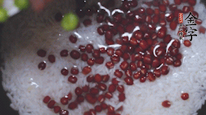 將炒好的食材和大米、紅豆一起放進(jìn)電飯鍋煮。