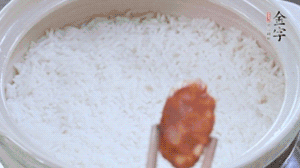 煮開(kāi)后轉(zhuǎn)小火，當(dāng)米飯出現(xiàn)小孔時(shí)，鋪上金字麻辣香腸。