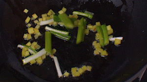 鍋中熱油，依次下姜粒、蔥段、蘆筍炒香。