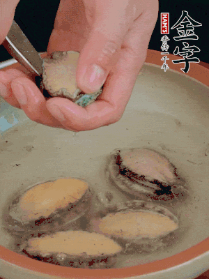 鮑魚加鹽、清水浸泡，用勺子挖出鮑魚肉。