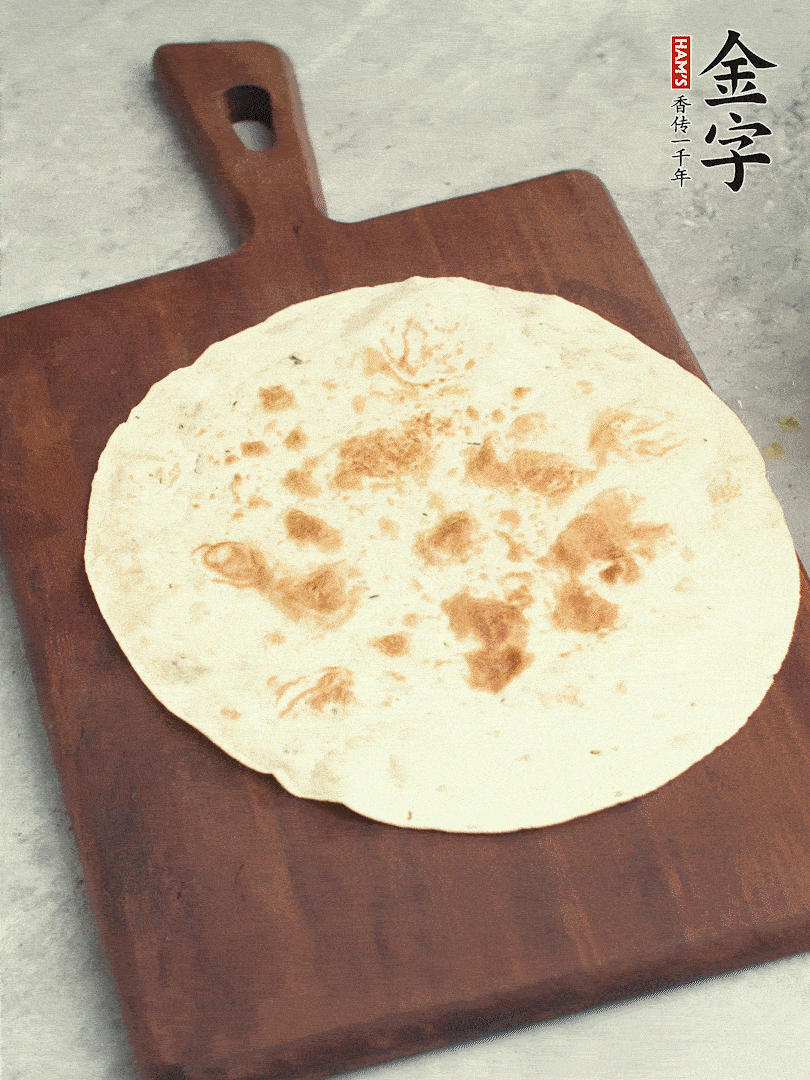 食材依次鋪在卷餅皮上，卷起來。