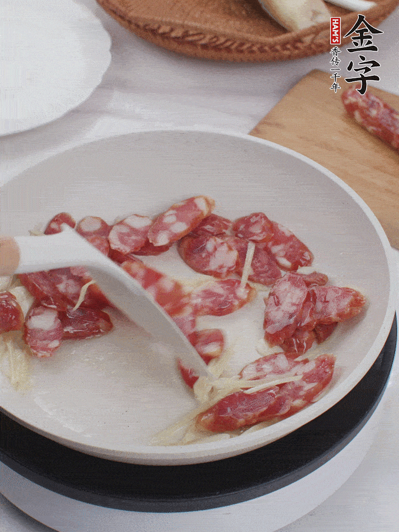 油溫3成熱時，下姜絲、蒜片、香腸炒出油脂。