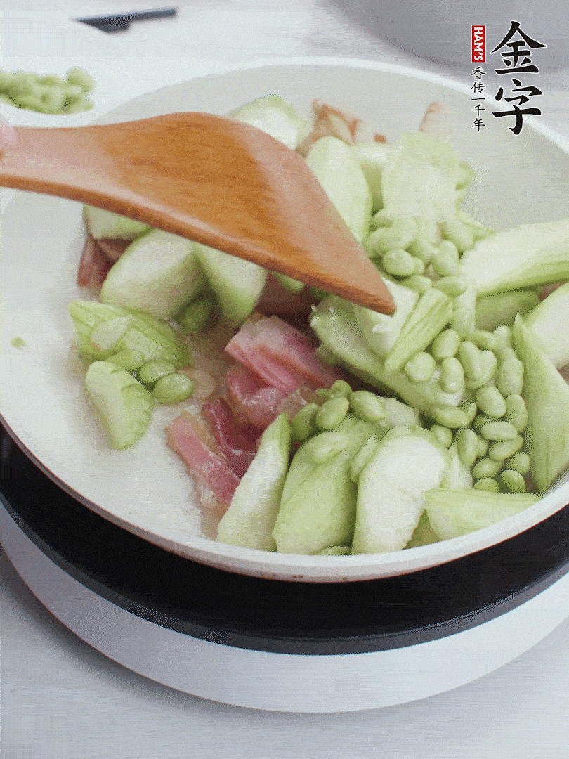 依次下絲瓜、青豆翻炒，炒至絲瓜打蔫縮小。