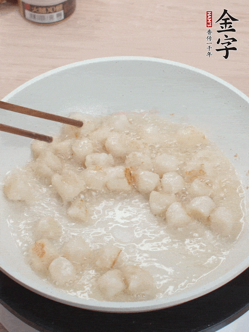 油溫4成熱，鮮貝蘸干淀粉下鍋煎，一面微黃后翻面。