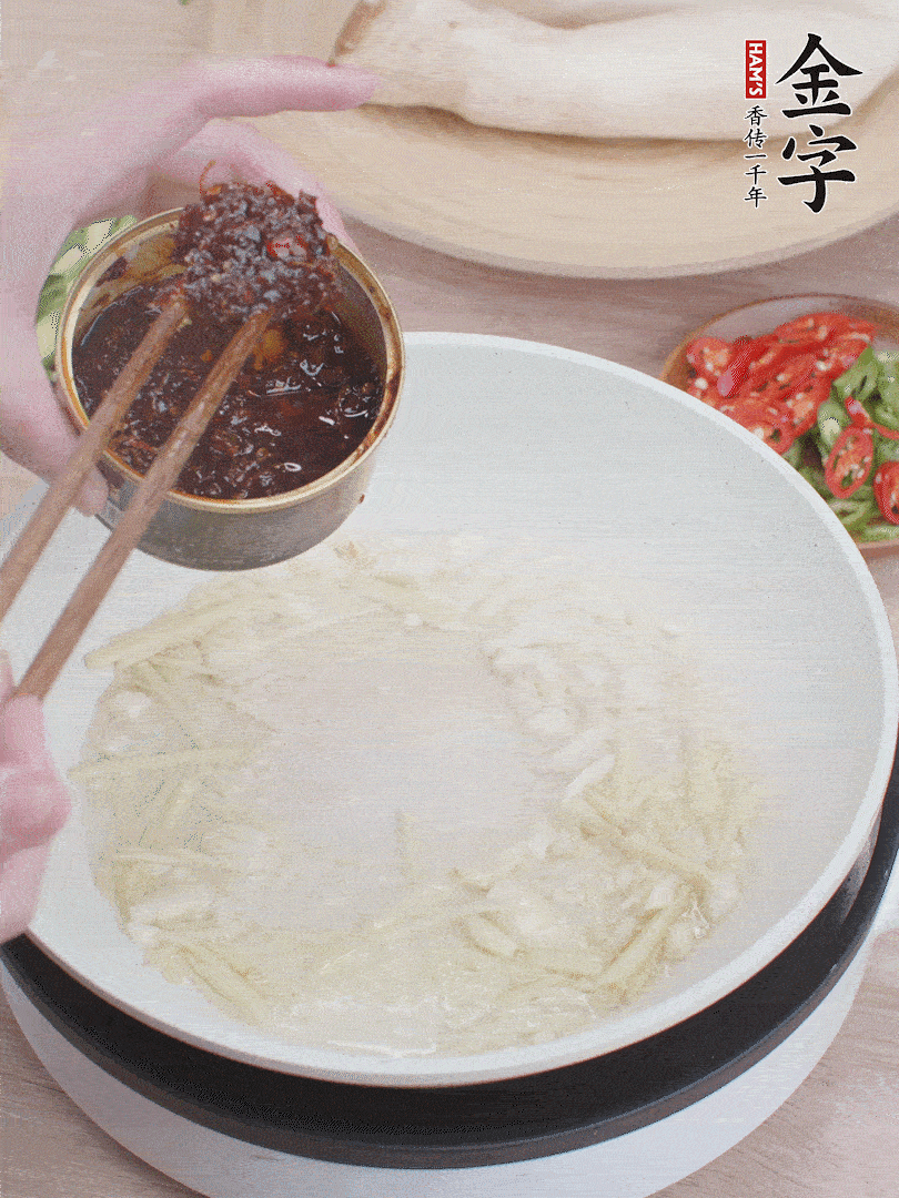 起鍋熱油，姜蒜、金字火腿干貝醬煸香。