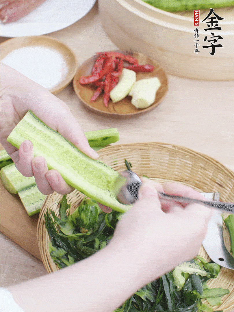 黃瓜削皮，對(duì)半切開(kāi)，勺子挖去內(nèi)瓤，斜刀切片。青蒜斜刀切段。