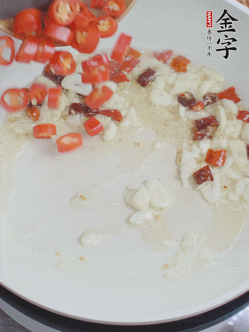 油6成熱，下蒜末、干紅辣椒煸炒，出香味后再放美人椒、香腸。