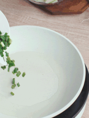 熱油下臘肉、蔥花煸炒，再下西葫蘆。