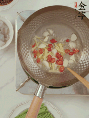 油7成熱時(shí)，下大蒜粒、姜絲、小米辣煸香。