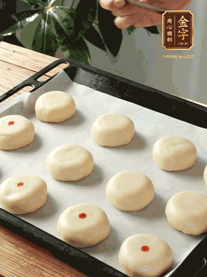 收口向下放在案板上，輕輕將月餅坯按扁，用筷子點(diǎn)紅點(diǎn)做裝飾