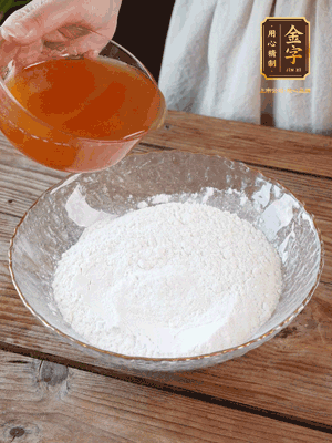 轉(zhuǎn)化糖漿、枧水、花生油攪拌均勻，加入面粉混合，醒發(fā)2小時。捏成23g一個的小球