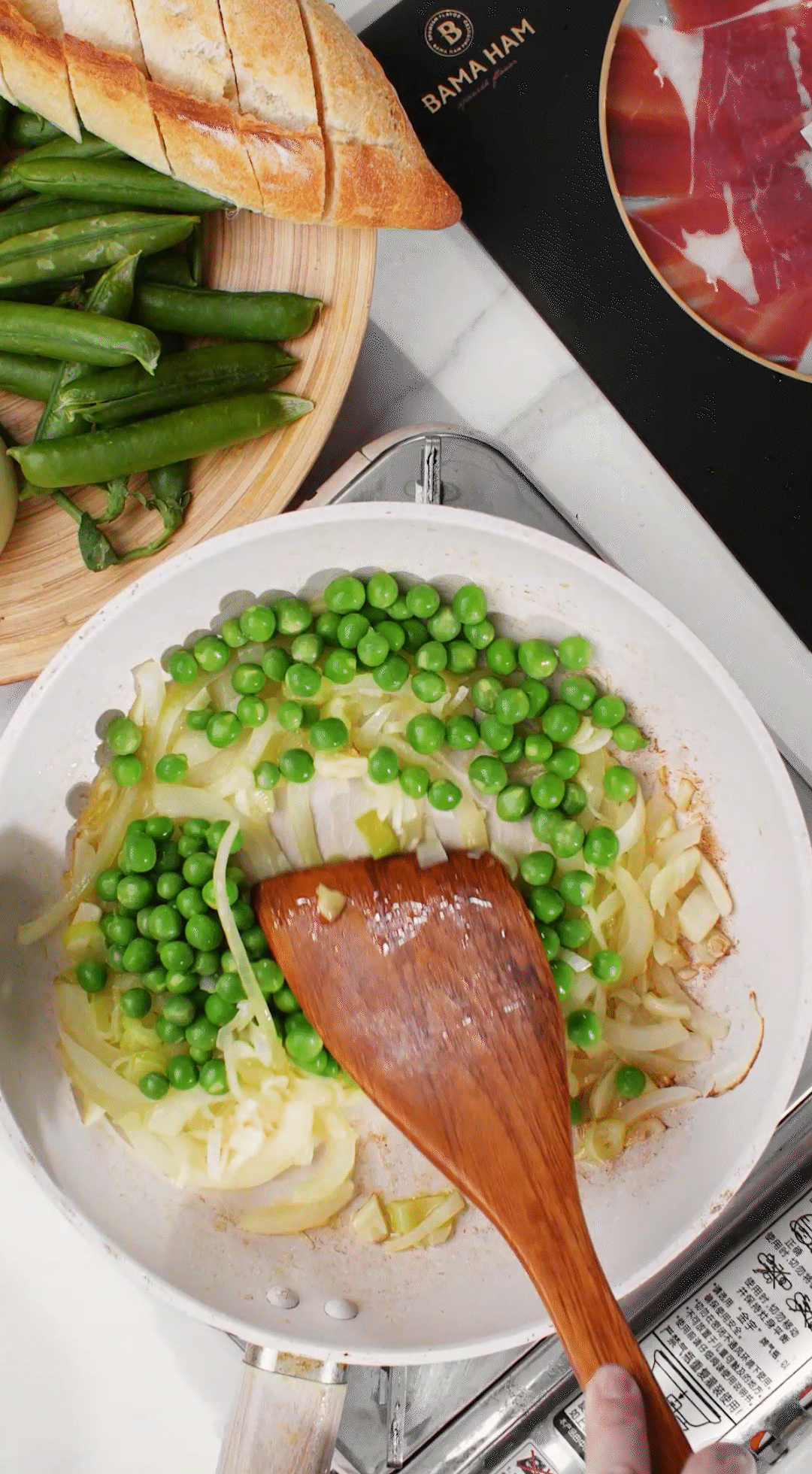 鍋中放入黃油融化，加入洋蔥絲、大蔥蔥白絲、蒜末翻炒變軟出香味。加入剛剛汆燙冰鎮(zhèn)后的豌豆，取出一點(diǎn)點(diǎn)待會(huì)擺盤裝飾用。加一點(diǎn)鹽 (和黑胡椒) 調(diào)味。