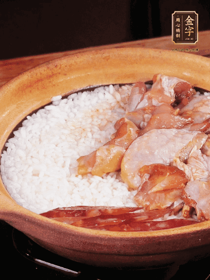 煮到椰子水微微收干轉(zhuǎn)小火，快速均勻鋪上雞肉、金字香腸