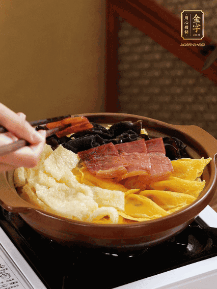 砂鍋底部鋪上娃娃菜，依次擺上肉皮、蛋餃、黑木耳、火腿