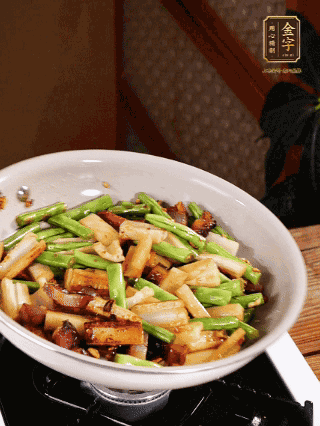 油熱下蒜末、干辣椒、醬肉煸炒出香味，依次下藕條、豆角翻炒均勻